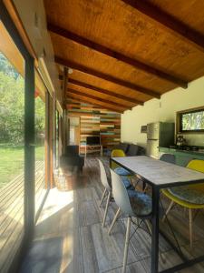 a kitchen and dining room with a table and chairs at Pucura Eco Lodge in Licán Ray