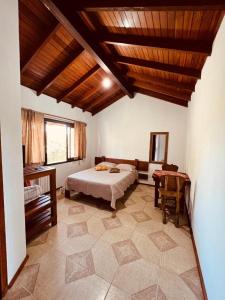 a bedroom with a bed and a table in it at Rodeio das Lagoas Pousada in Cambara do Sul