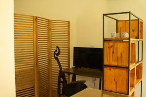 una habitación con un escritorio con televisión y un espejo en Loft com piscina natural em Cachoeiras de Macacu, en Cachoeiras de Macacu