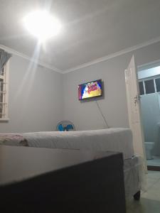 ein Schlafzimmer mit zwei Betten und einem Fernseher an der Wand in der Unterkunft Fife Avenue Guest House in Harare