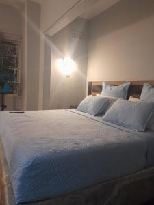 ein Schlafzimmer mit einem großen Bett mit einer Lampe an der Wand in der Unterkunft Fife Avenue Guest House in Harare