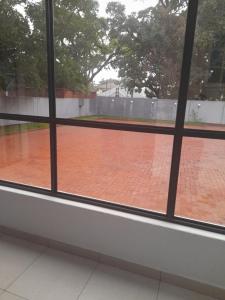 ein Blick auf einen Tennisplatz durch ein Fenster gesehen in der Unterkunft Fife Avenue Guest House in Harare