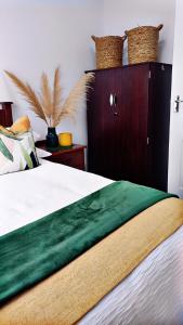 Un dormitorio con una cama con cabecero de madera. en Forest Green Unit 2, en Durban