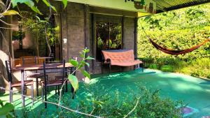 a porch with a hammock and a table and chairs at Chalets Silencio del Bosque in Fortuna