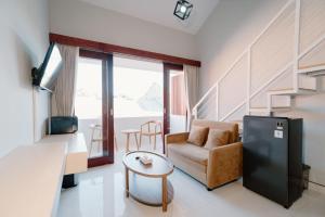 a living room with a couch and a table at Pondok Puspa Sumekar in Seminyak