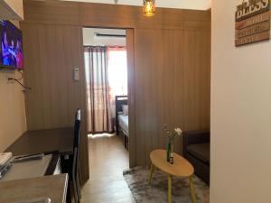 Il comprend un petit salon avec une table et une cuisine. dans l'établissement Netflix & Chill at Pablo's Homestay-Grace Residences Tower 4, à Manille
