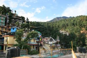 a group of buildings on a hill with trees at Green Hotel in Dharamshala