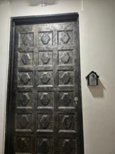 an old wooden door with a clock on a wall at ApartaLoft 12, NevadaLofts Sabaneta in Sabaneta