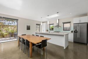 a kitchen and dining room with a wooden table and chairs at Seaside Getaway in Point Lonsdale