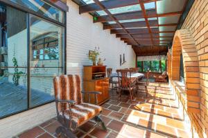 a screened in porch with a table and chairs at Casa Tissot- 5 Quartos no Centro de Gramado in Gramado