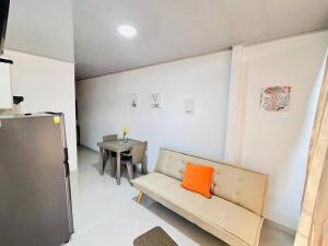 a room with a couch with an orange pillow on it at Alojamiento Aipe-Huila, cerca al Desierto-Tatacoa in Aipe