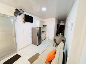 a small kitchen with a couch and a refrigerator at Alojamiento Aipe-Huila, cerca al Desierto-Tatacoa in Aipe