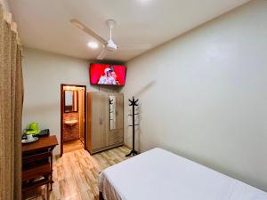 a bedroom with a bed and a tv on the wall at Habitación Céntrica en Iquitos - Casa Alemi 5 in Iquitos