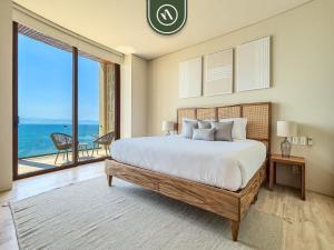 a bedroom with a large bed with a view of the ocean at Luxury 4 BR Oceanfront Condo - Private Beach - Pool in Cruz de Huanacaxtle +55 photos