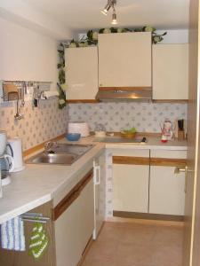 a kitchen with white cabinets and a sink at Ferienwohnung Adelheid in Eggenbach