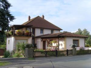 a white house with a fence in front of it at Ferienwohnung Adelheid in Eggenbach