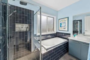 a bathroom with a bath tub and a sink at Serenity Nook Cottage in Point Lonsdale +12 photos
