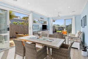 a living room with a wooden table and chairs at Serenity Nook Cottage in Point Lonsdale