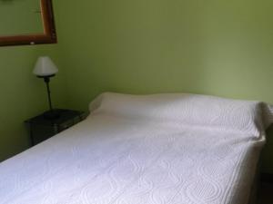 a white bed in a green bedroom with a lamp at Charmant 2 Pièces, Balcon, Wi-Fi, Proche Pistes, Chantemerle - FR-1-762-9 in Saint-Chaffrey