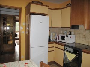a kitchen with a white refrigerator and a microwave at Charmant 2 Pièces, Balcon, Wi-Fi, Proche Pistes, Chantemerle - FR-1-762-9 in Saint-Chaffrey +2 photos