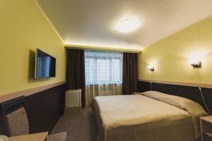 a hotel room with a bed and a flat screen tv at Hotel Complex Rybinsk in Rybinsk