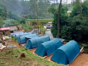 a group of blue tents in a field at Wulandari Riverside in Kertamanah