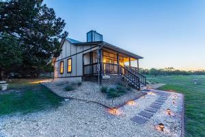 une petite maison sur un champ avec un arbre dans l'établissement Appian Way Avalon Cottage, à Fredericksburg