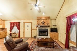 un salon avec un canapé et une cheminée dans l'établissement Appian Way Avalon Cottage, à Fredericksburg