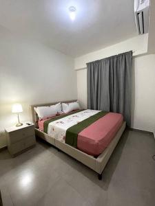 a small bedroom with a bed and a night stand at Luxury Santo Domingo Tower Condo in Santo Domingo +42 photos