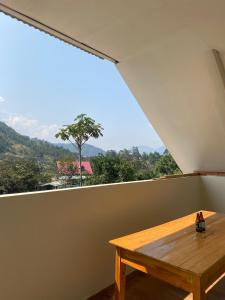 a wooden table in a room with a large window at LagunaNegra Oxapampa in Palmira