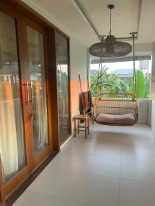 a room with a porch with a chair and a window at Base Villa in Canggu