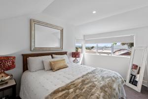 a bedroom with a bed and a large window at The Dunes - Whangamata Holiday Apartment in Whangamata