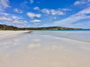 a view of a beach with the water and sky at Two Buoys Emu Bay in Emu Bay