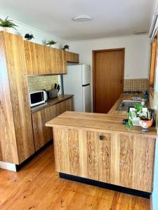 a kitchen with wooden cabinets and a counter top at Two Buoys Emu Bay in Emu Bay