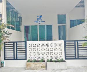 a white building with a blue fence and a door at Happy@samed in Ko Samed