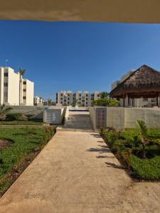 a walkway leading to a building with a gazebo at Family Department in Tulum