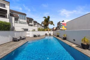 a swimming pool in the backyard of a apartment at The Dunes - Whangamata Holiday Apartment in Whangamata