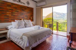 une chambre avec un lit et une grande fenêtre dans l'établissement Honda Colonial Magdalena Resort, à Honda 62 autres photos