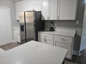 Una cocina con gabinetes blancos y un refrigerador de acero inoxidable. en Homey 2br Home Near Dt&airport, en Austin