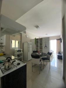 a kitchen with a stove and a table with chairs at Departamento Práctico y Confortable in San Miguel de Tucumán
