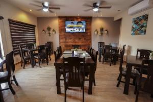 a dining room with tables and chairs and a tv at Royal Suite Cananea in Cananea