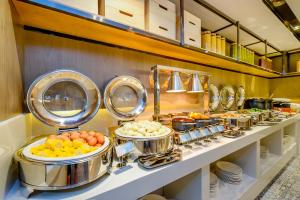 a buffet line with pots and pans of food at Echarm Hotel Chongqing Dadukou Commercial Center Xinshancun Metro Station Branch in Dadukou