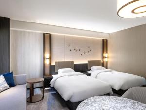大阪Grand Prince Hotel Osaka Bay的一间酒店客房,房间内设有四张床