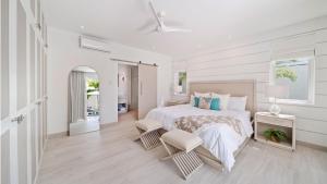 - une chambre blanche avec un lit et deux chaises dans l'établissement Porters Place 11 home, à Saint James