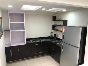 a kitchen with black cabinets and a white refrigerator at Casa privada en Montenegro Quindio in Montenegro