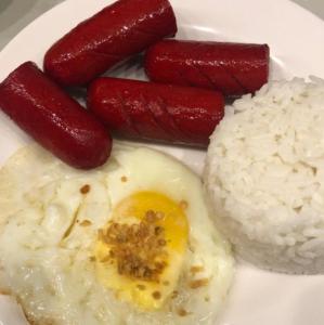 a plate of food with sausage and rice on it at Dreamway House Bed & Breakfast in Roxas City +12 photos