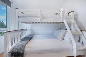 Seascape Sanctuary - Palm Beach Resort-style Bliss في غولد كوست: سرير بطابقين أبيض في غرفة بيضاء مع سلم +14 صورة