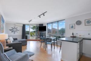 Seascape Sanctuary - Palm Beach Resort-style Bliss في غولد كوست: مطبخ وغرفة معيشة مع طاولة وكراسي