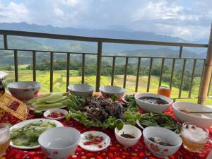 a table topped with bowls and plates of food on a table at Homestay Trúc Sơn in Hong Ha