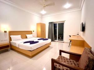 una camera da letto con un letto e una sedia di Morjim Sunset Hotel a Morjim